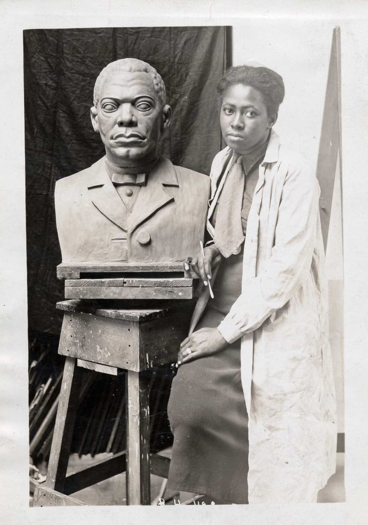 Sculptor Selma Burke with her portrait bust of Booker T. Washington.