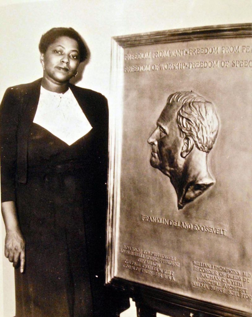 Sculptor Selma Burke with her relief plague of FDR.